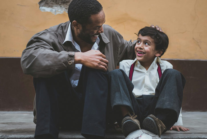 Child and adult sitting and laughing Photo by Sebastián León Prado on Unsplash